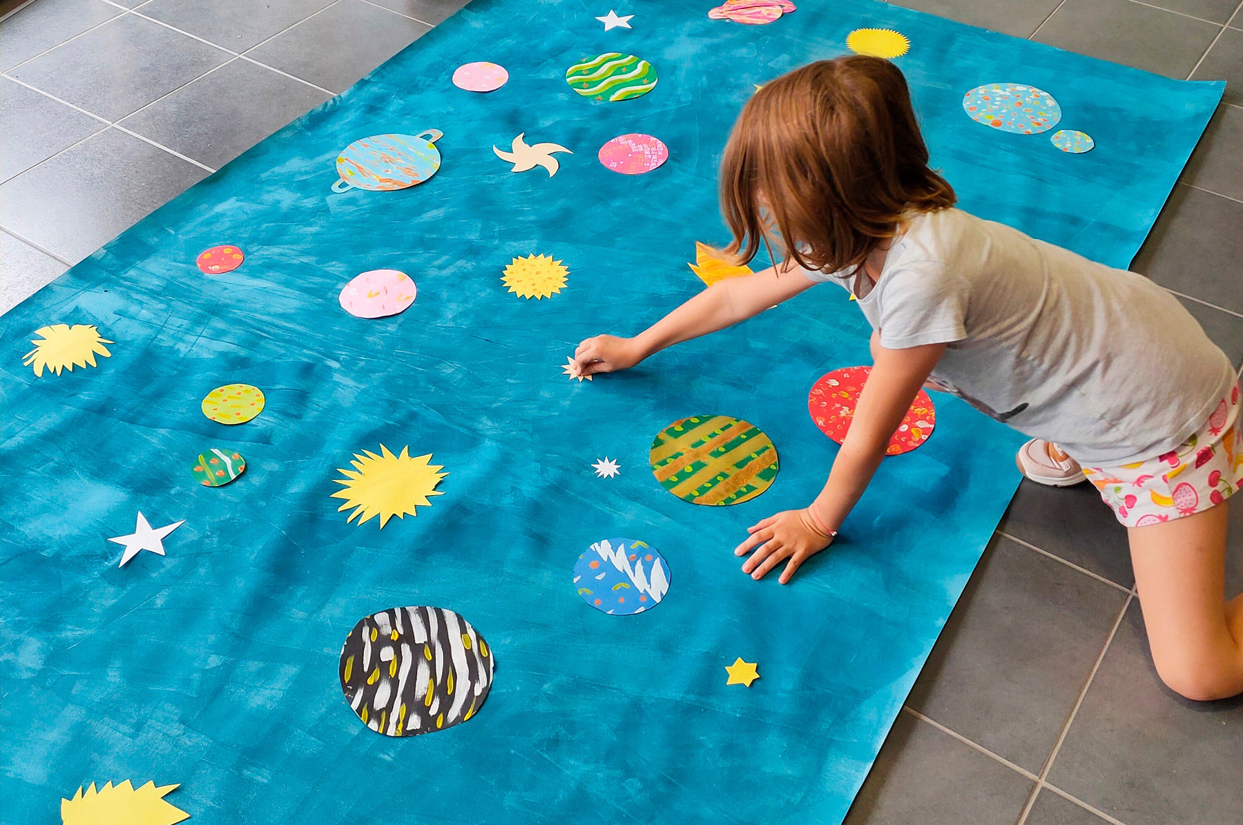 atelier créatif de fresque pour les enfants avec du papier découpé et de la peinture en lien avec l'album jeunesse Dans la peau d'une astronaute